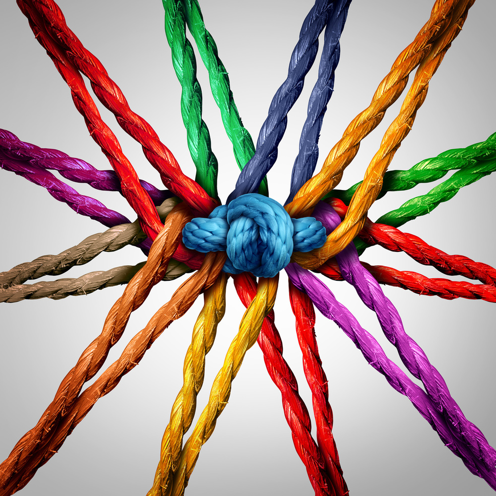 Group holding together as different ropes connected and tied and linked together in the center by a knot as a strong  unbreakable chain and community trust and faith metaphor.